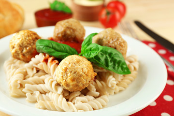 Pasta with meatballs on plate, on wooden  table background