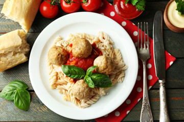 Pasta with meatballs on plate, on wooden  table background