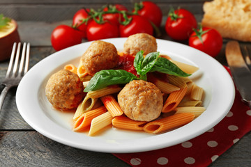 Pasta with meatballs on plate, on wooden  table background