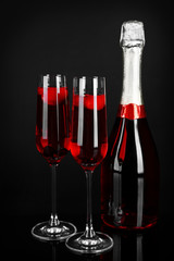 Glasses of champagne with berries on black background