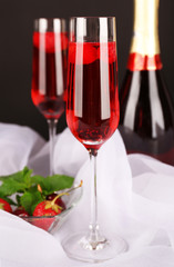 Glasses of champagne with berries on black background