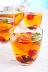 Fruity punch in glassware on wooden table, closeup