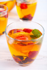Fruity punch in glassware on wooden table, closeup