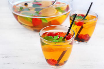 Fruity punch in glassware on wooden table, closeup