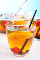 Fruity punch in glassware on wooden table, closeup