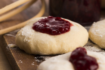 Dough with marmelade on wooden board