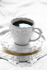 Morning cup of coffee on comfortable bed in bedroom