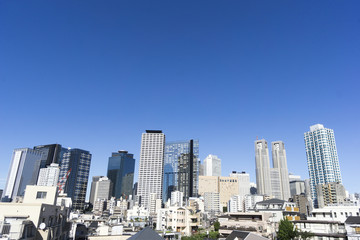 Naklejka premium 東京都庁と新宿高層ビル群と開発中の西新宿5丁目住宅街 快晴青空 コピースペース 新しいビルが竣工しています 2015年7月撮影