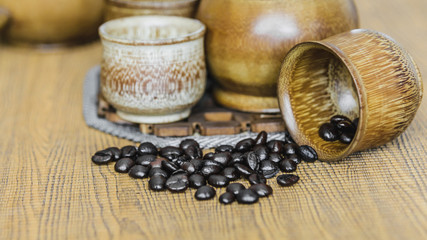 Obraz na płótnie Canvas Soft focus image of coffee beans and coffee cups set on wooden b