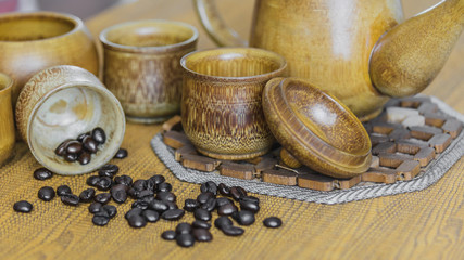 Soft focus image of coffee beans and coffee cups set on wooden b