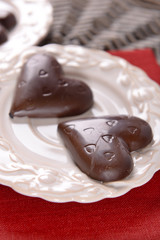 Chocolate heart shaped candies on sticks in white plate, closeup