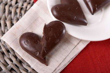 Chocolate heart shaped candies on sticks in white plate, closeup
