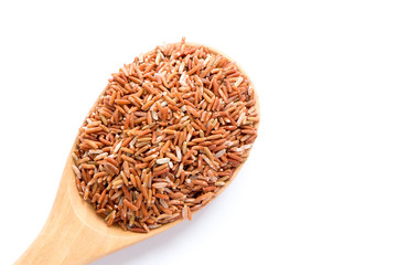 brown rice on wooden spoon isolate on white background.