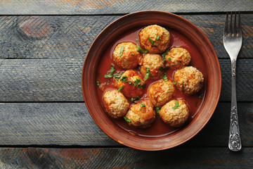 Meat balls with tomato sauce, on wooden background