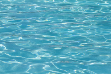 Blue pool water with sun reflections