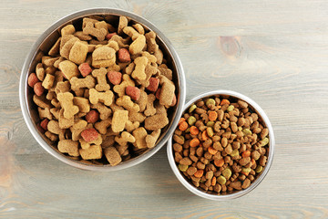 Dog food in bowls on wooden table