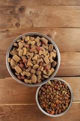 Dog food in bowls on wooden table