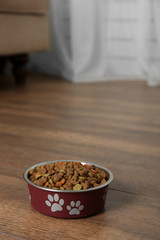 Dog food in bowl on floor at home