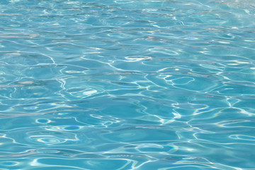 Blue pool water with sun reflections