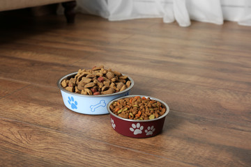 Dog food in bowls on floor at home