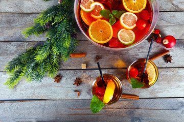 Sangria in bowl and glasses with Christmas decoration on wooden table close up