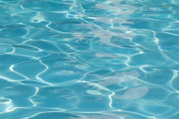 Blue pool water with sun reflections