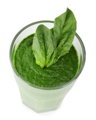 Glass of green vegetable juice with basil isolated on white