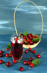 Glass of fresh juice with cherries on wooden table close up