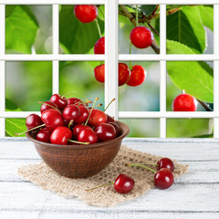 Sweet cherry on the wooden board and garden outside the window