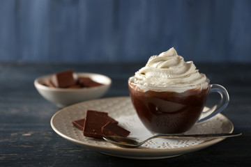 Cup of coffee with cream on color wooden background