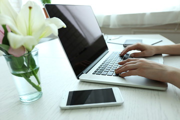 Woman using laptop at workplace in office