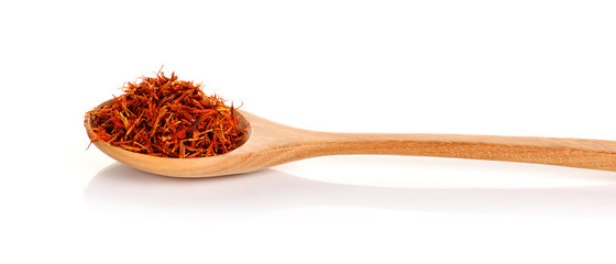 Safflower petals in a spoon on white background