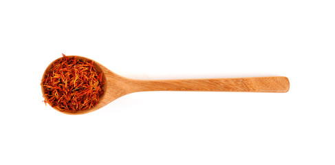 Safflower petals in a spoon on white background