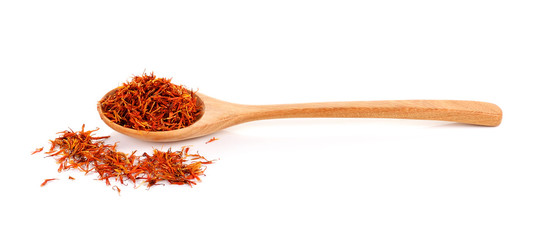 Safflower petals in a spoon on white background