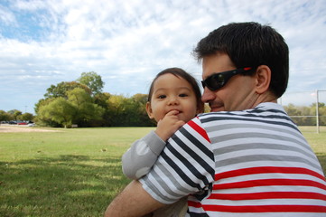 Fototapeta premium Father and his 1.1 years old daughter were at a park. It was a quality time for them whenever he had his day off, he would take his daughter outside to get a fresh air and have fun together