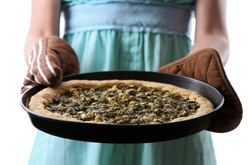 Woman holding open pie with spinach close up