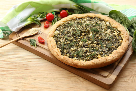 Open pie with spinach and tomato cherry on table close up