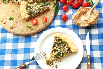 Slices of open pie with spinach and tomato cherry on table close up