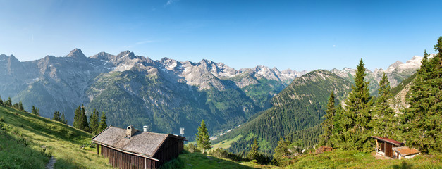Fototapeta na wymiar Rustic log cabins on an Alpine plateau