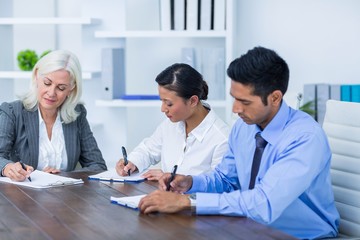 Business people writing on clipboards