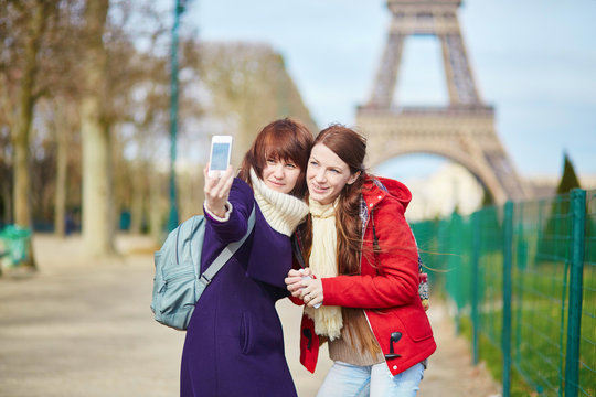 Two cheerful girls in Paris doing selfie