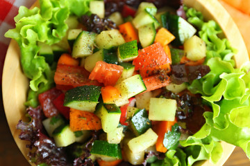Wooden bowl of fresh vegetable salad, closeup