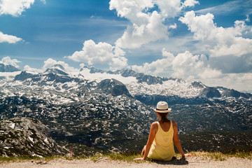 Young girl sitting on the ground in mountains Dachstein Krippens Austria Alps