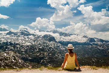 Fototapeta na wymiar Young girl sitting on the ground in mountains Dachstein Krippens Austria Alps