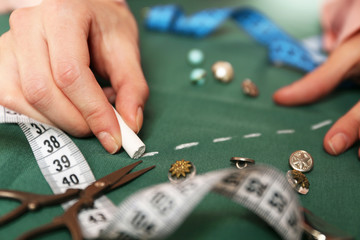 Closeup hands of seamstress at work with cloth fabric