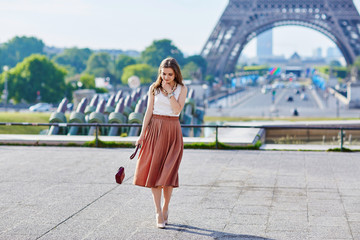 Fototapeta premium Beautiful young Parisian woman near the Eiffel tower