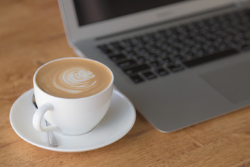 laptop with coffee cup on old wooden table ( Filtered image proc