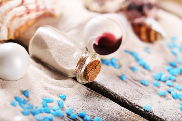 Collection of seashells with sand on wooden surface, closeup