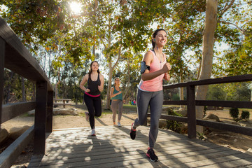 Fototapeta premium Jogging group of people in park outdoors healthy and active females vibrant young energetic positive