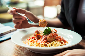 close up of woman eating spaghetti meatball